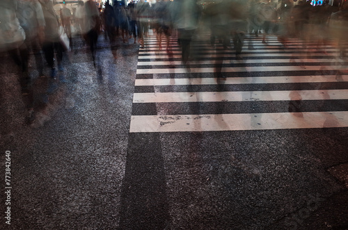 A long exposure photo of a crosswalk with blurred motion pedestrians, taken at a large intersection in Tokyo, Japan                                                