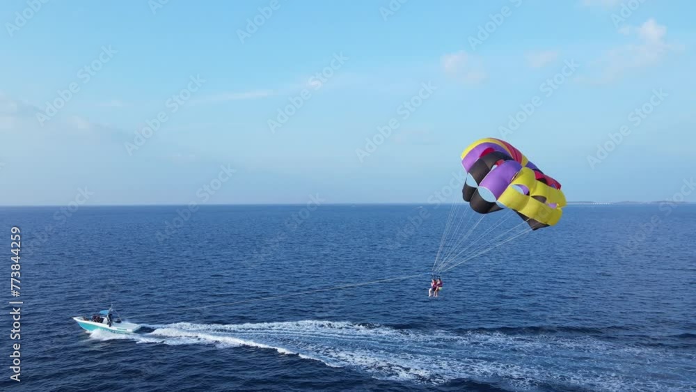 Couple on Island Vacation Parasailing at Sea, Drone View Couple on Island Vacation Parasailing at Sea, Drone View
