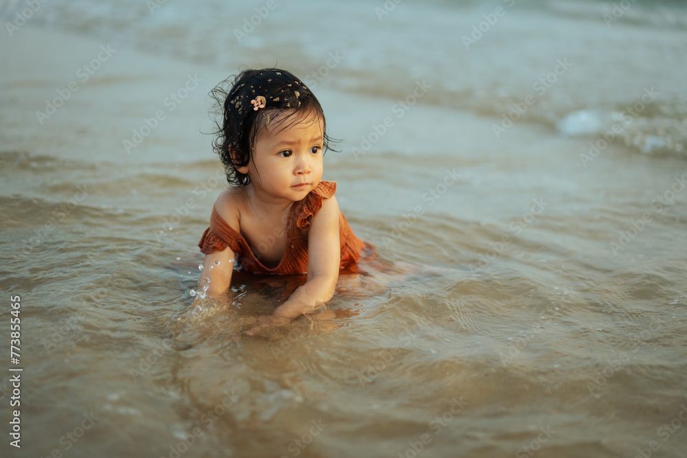 happy toddler baby girl playing sand and water on sea beach happy toddler baby girl playing sand and water on sea beach