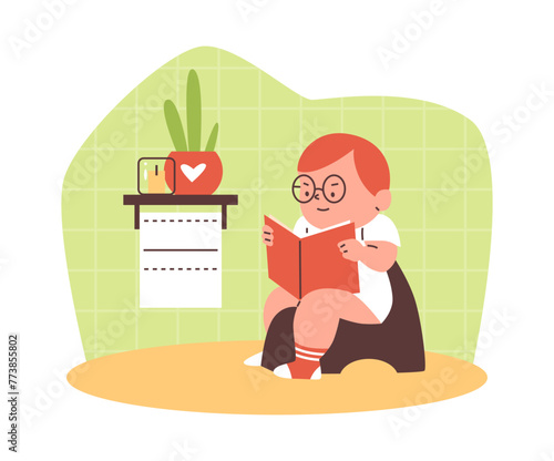 A boy sits on a chamber pot with a book in the toilet room.