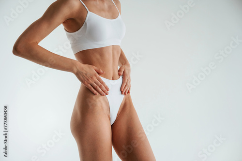 Woman in white underwear with slim body type against white background