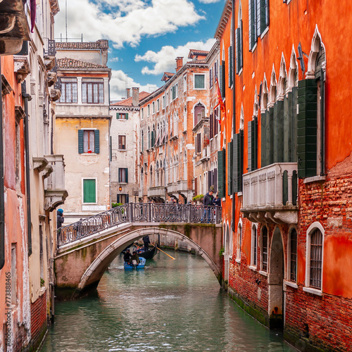 Bridge over a typical canal and its tourists, in Venice, Veneto, Italy