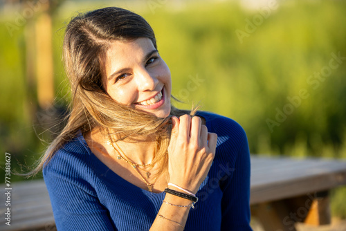 Joyful woman smiling while enjoying a sunny day outdoors.