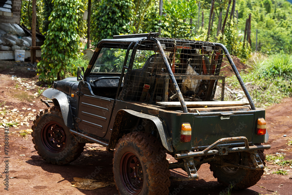 Jangkrik's jeep is parked in front of the garden house during the day Jangkrik's jeep is parked in front of the garden house during the day