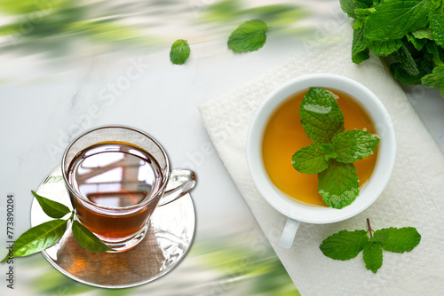 Mint tea in a glass cup on a wooden background with fresh leaves and lemon tea. photo
