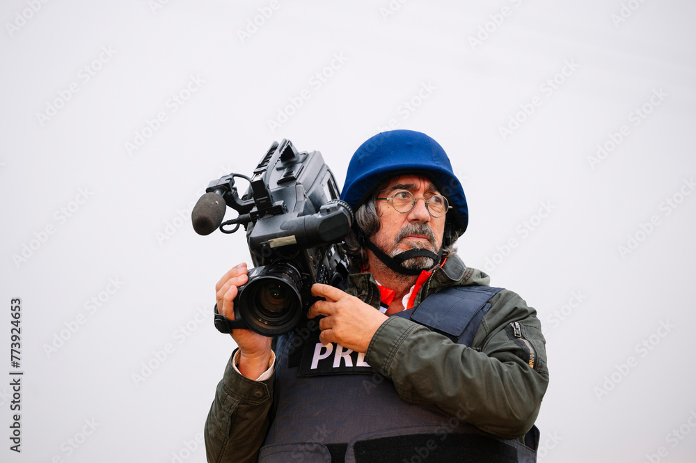 Reporter in bulletproof vest holding a video camera Reporter in bulletproof vest holding a video camera