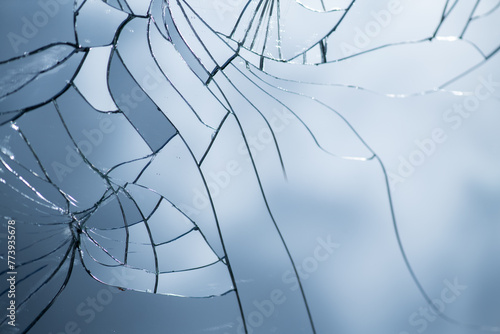 background of cracked mirror with broken glass shards reflecting the blue sky photo