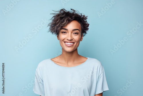 A woman with short hair is smiling and wearing a blue shirt