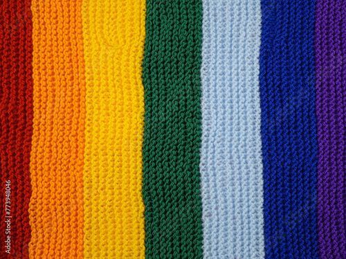 Part of wool hand-knitted scarf in rainbow colors, background 