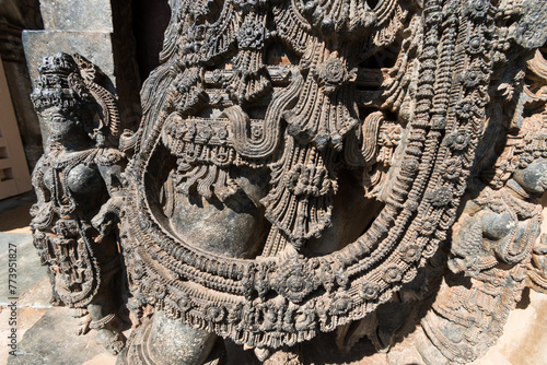 Detail of the intricately carved ornamentation on the sculpture of a guardian deity at the ancient Hoysaleshwara temple complex in Halebidu in Karnataka. photo