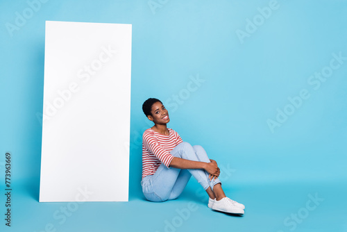Full size profile side photo of young girl guy sit floor promo ads isolated over blue color background