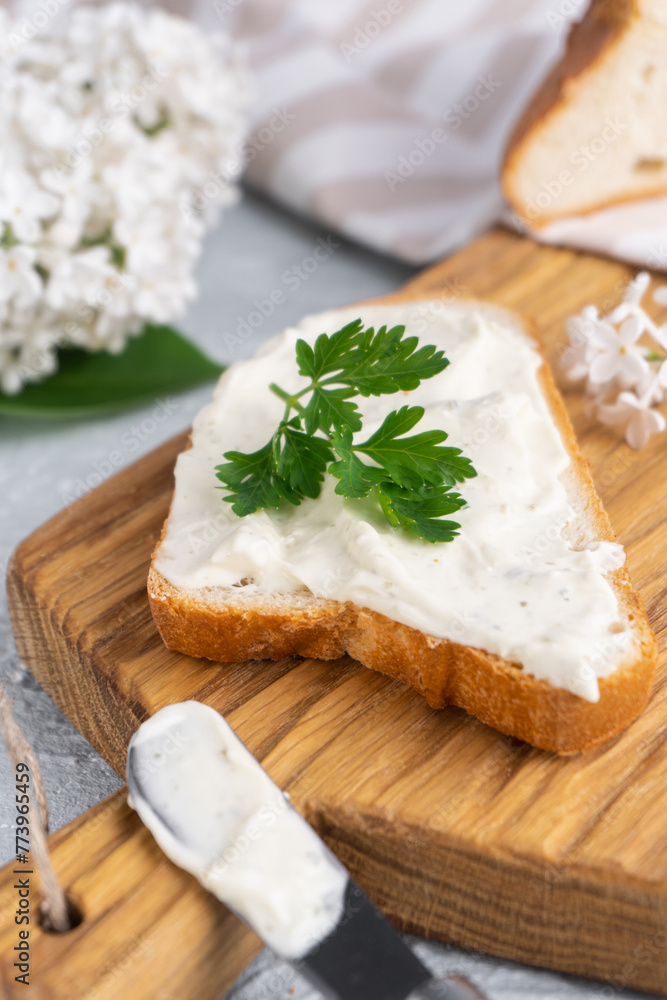 Cream cheese with herbs and seasoning on slice of fresh crunchy rye bread with cheese knife nearby Cream cheese with herbs and seasoning on slice of fresh crunchy rye bread with cheese knife nearby