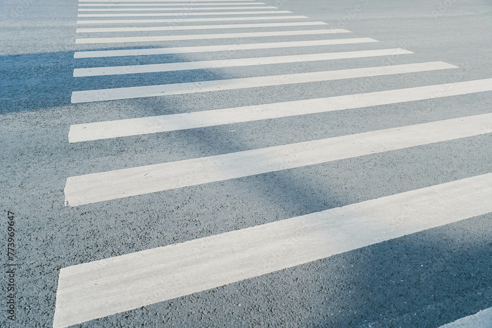Fototapeta premium pedestrian crossing, white stripes on black asphalt, road markings zebra crossing, place to cross the road, traffic rules