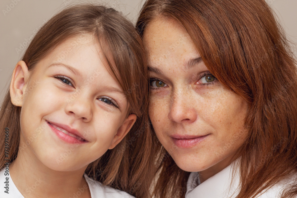 Portrait of mother and daughter hugging and looking at camera Portrait of mother and daughter hugging and looking at camera