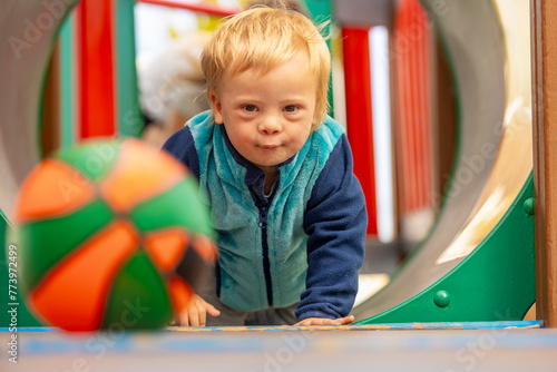 Toddler with Down syndrome having fun at playground with toddler photo