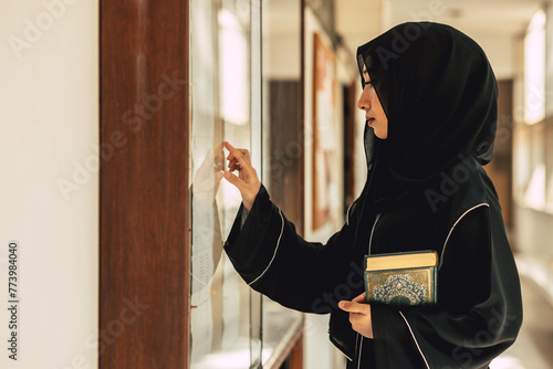 Muslim niqab woman read and learning the Quran and faith The Holy Al Quran book. Arab saudi black chador lady. photo