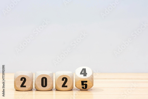 Wooden 2024 to 2025 new year white background. 
Word 2024 - 2025 wood cube on wooden desk for copy space. 