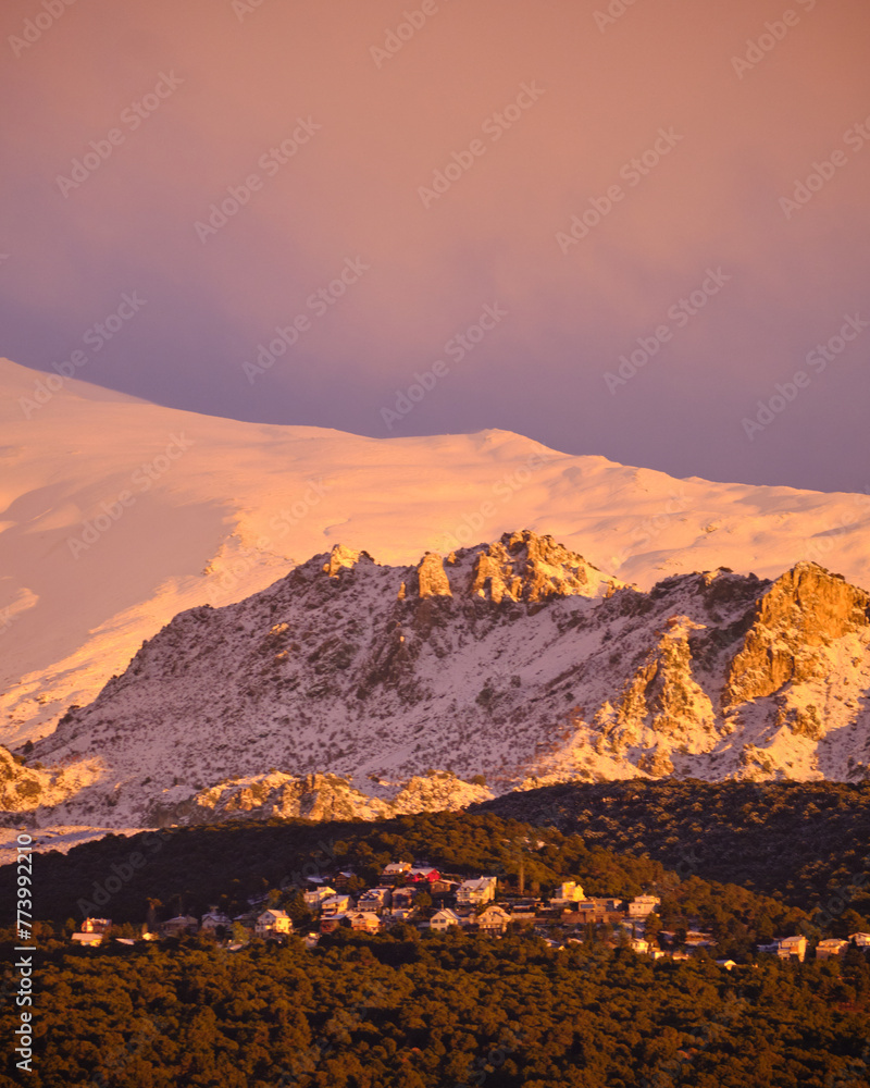 Views of Sierra Nevada from Granada during the golden hour at sunset with the peaks full of snow.