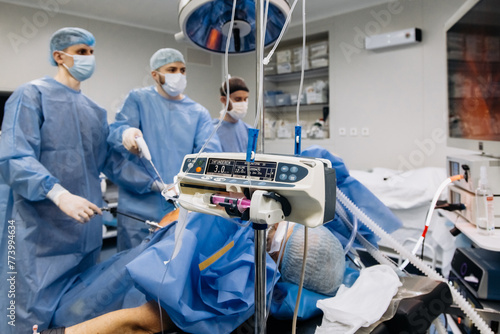 A group of medical surgeons in the operating room during an operation. A patient on the operating table during laparoscopic abdominal surgery. The concept of modern medical equipment. photo
