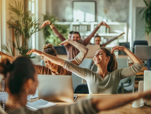 A group of coworkers stretching together in the office during a mid-day break