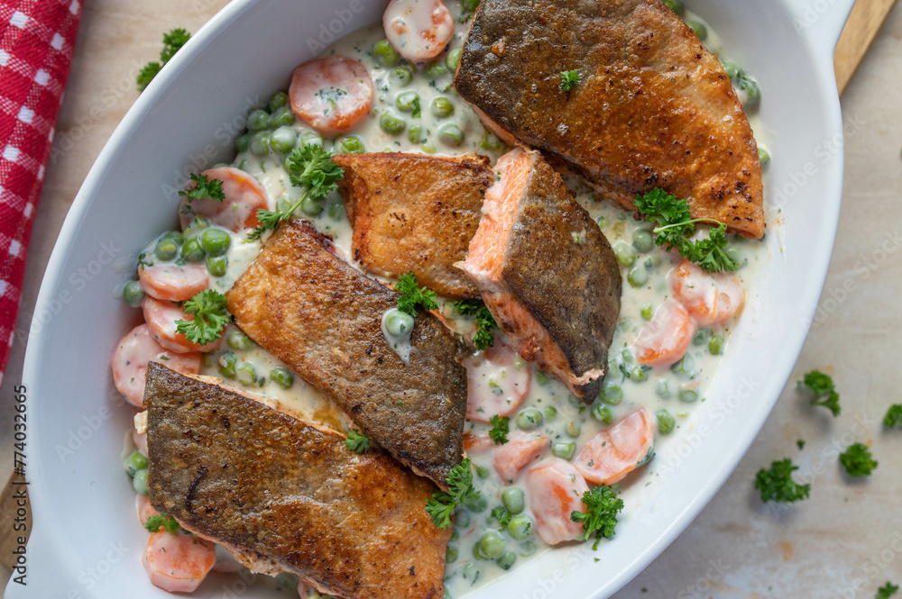 Pan fried salmon with skin and creamy peas and carrots