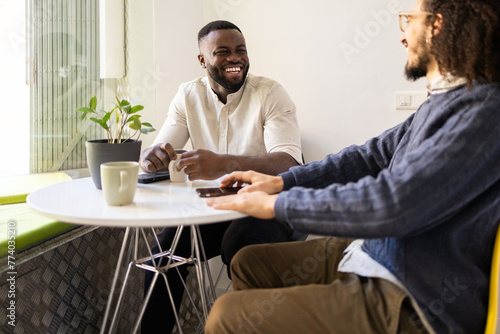 Joyful banter between two men at a cozy home environment photo