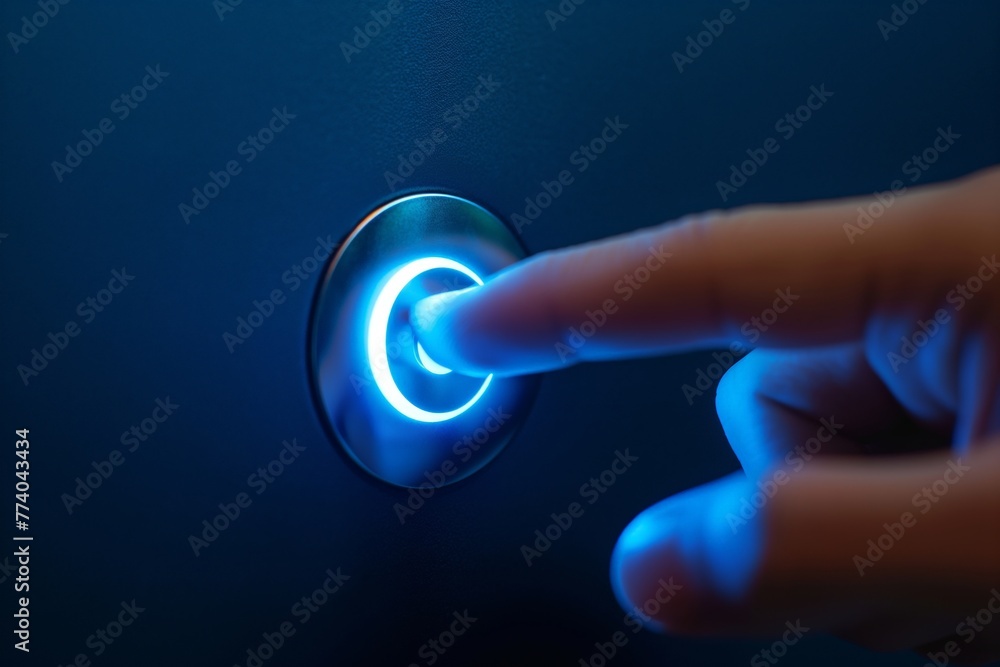 Close-up of a finger pressing a glowing blue power button on a dark background. - obrazy, fototapety, plakaty 