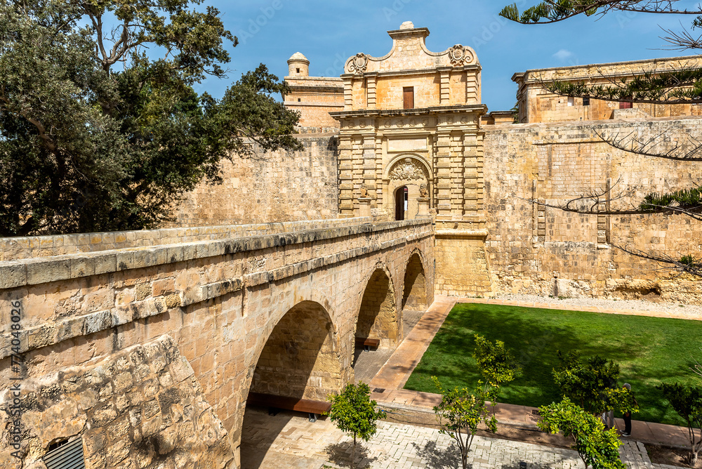 Entrance bridge and gate to Mdina, a fortified medieval city in the Northern Region of Malta.