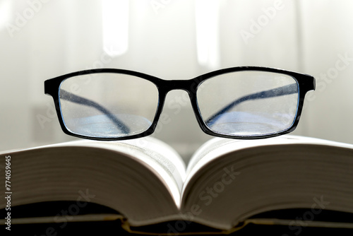 Close-up photo of eyeglasses on the book in education and reading book concept