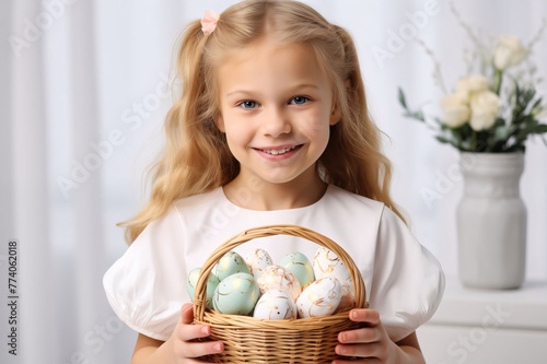 Cute little girl with basket of easter eggs on light background