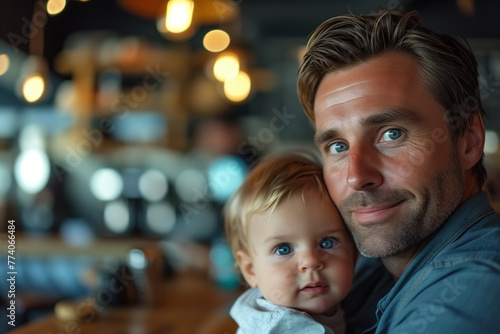 A man tenderly holds a child in his arms in a cafe, showing the tender bond between father and child. The man's face expresses love and care, copy space