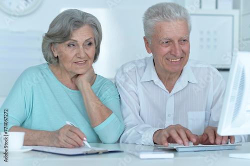 portrait of two old people working with a laptop in the office