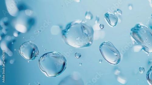 Abstract water droplets on the blue background. Beautiful big drinking water droplets on the light blue background. Bright blue background