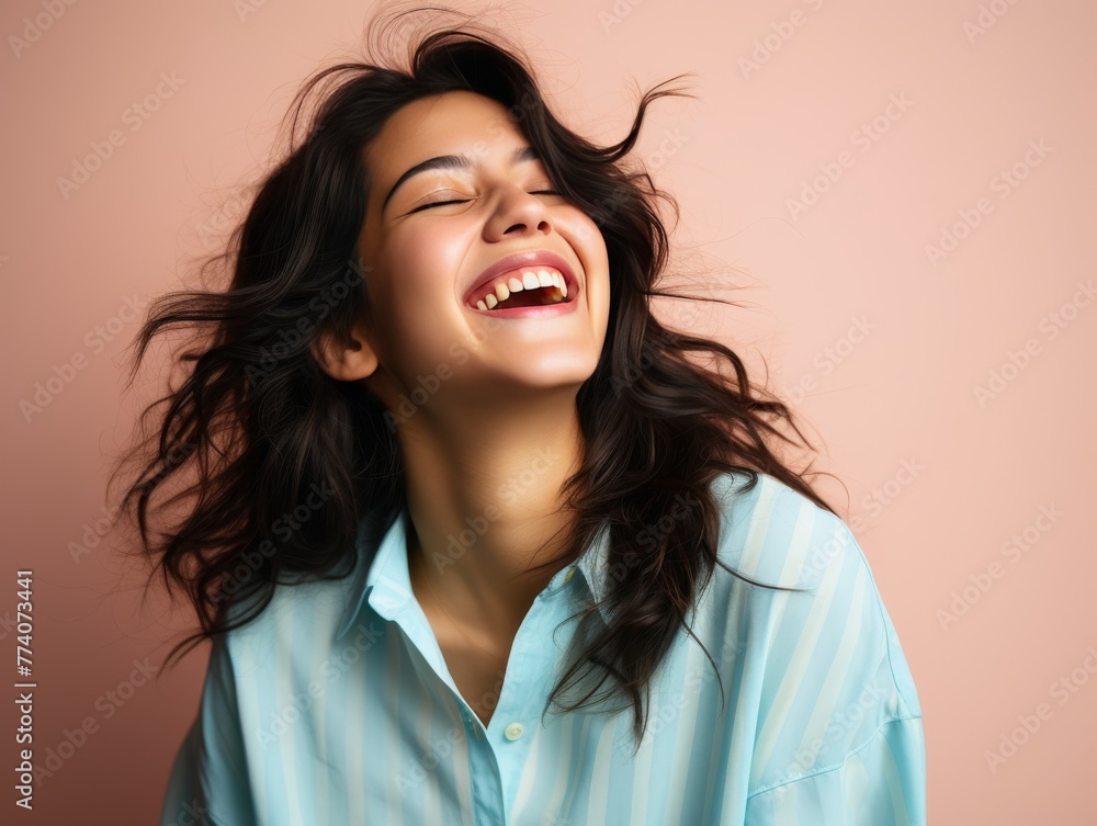 A woman with long hair is smiling and laughing while wearing bright clothing A woman with long hair is smiling and laughing while wearing bright clothing
