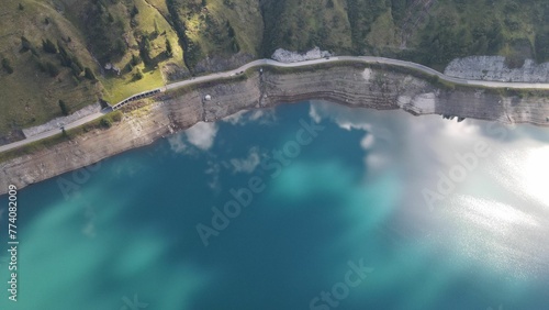 Aerial of Lake Fedaia reflecting the clouds in the Dolomites range of northeastern Italy
