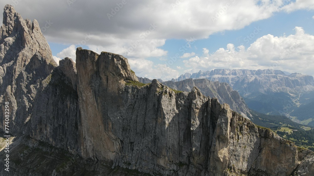Aerial shot of Seceda Mountain with floating clouds above in the Alps of Italy Aerial shot of Seceda Mountain with floating clouds above in the Alps of Italy