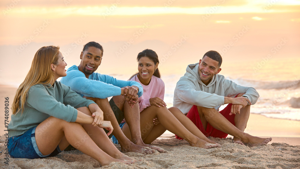 Obraz premium Young Couple With Friends In Casual Clothing On Vacation Sitting On Beach Watching Sunrise Together