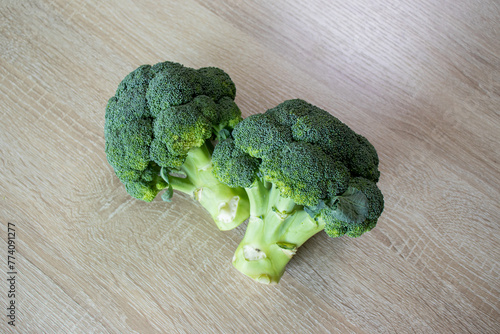 Two raw broccoli on wooden background.