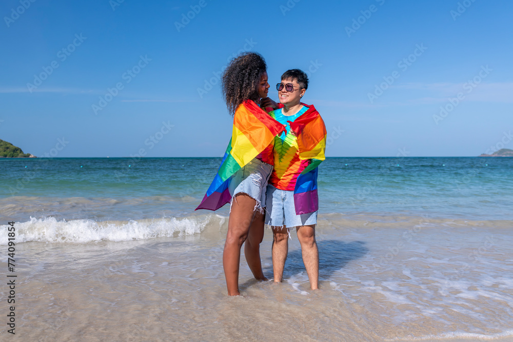 Happiness Lesbian LGBTQ couple holiday summer on the beach with show a rainbow flag a symbol of the LGBT community freedom Equality love concept. Happiness Lesbian LGBTQ couple holiday summer on the beach with show a rainbow flag a symbol of the LGBT community freedom Equality love concept.