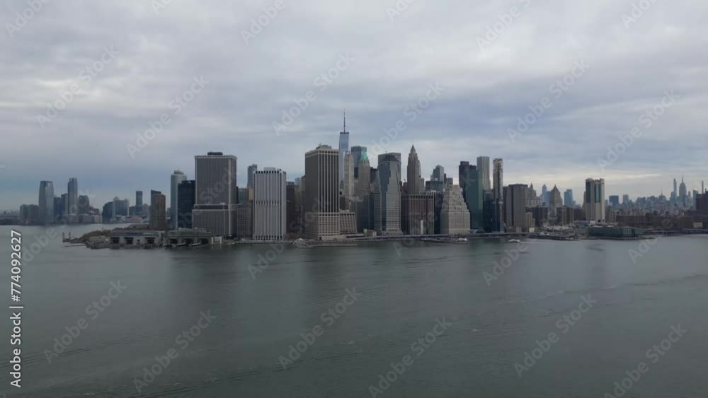 Drone shot of city buildings with a sea view under a cloudy sky