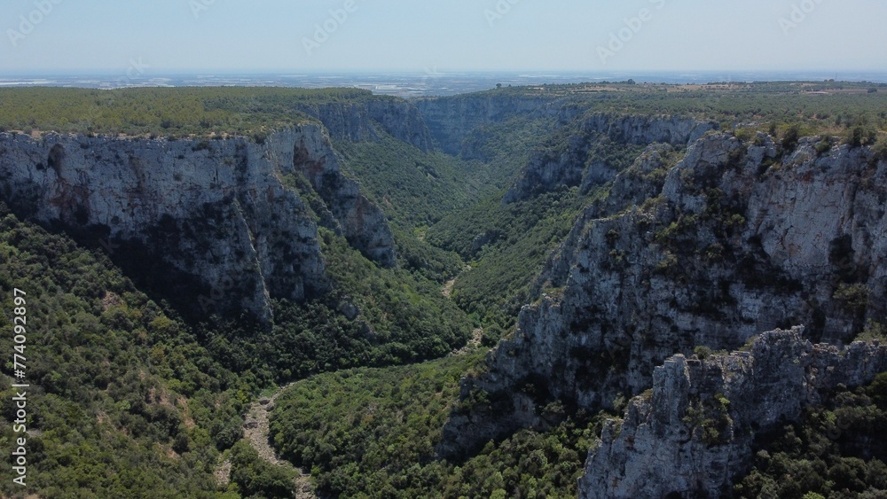 Aerial view of a winding road in a green mountainous valley