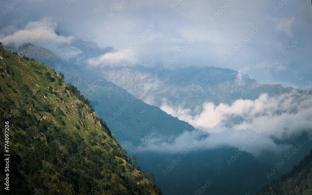 Landscape of a green mountain with foggy sky and white clouds