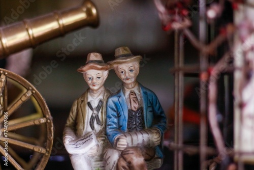 Figurines of elderly with hats, sitting by eath other photo