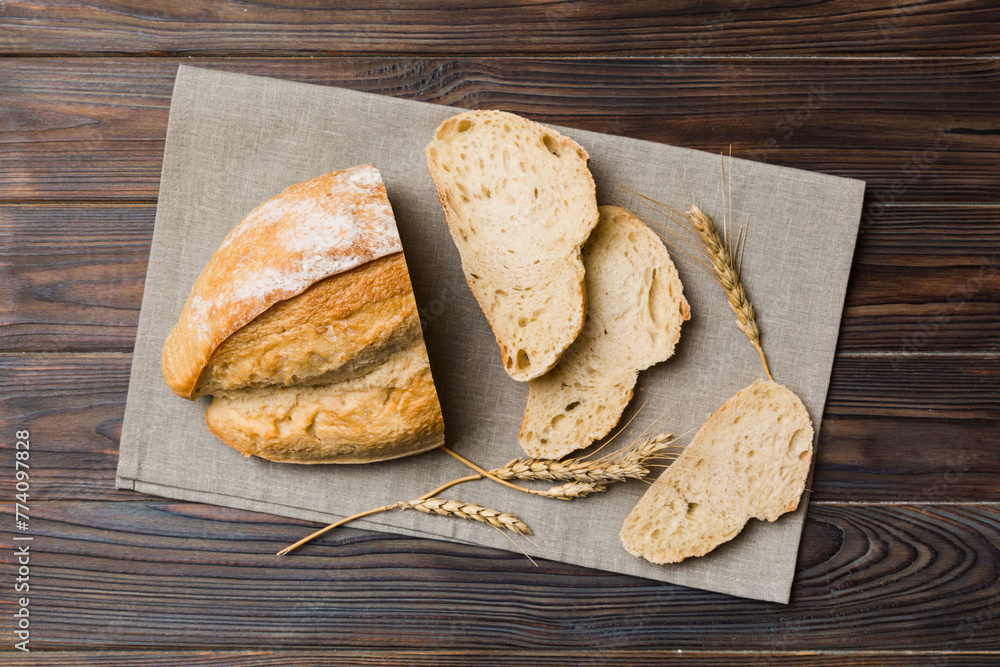 Freshly baked bread slices on napkin against natural background. top view Sliced bread