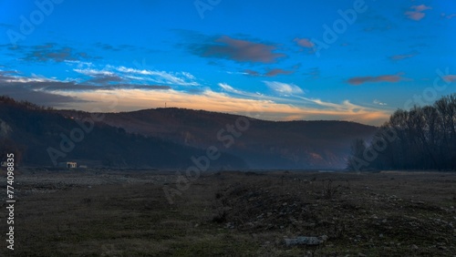 Low-angle view of a beautiful forest near the mountains in Romania at sunset