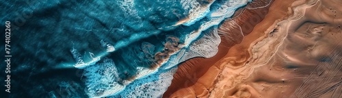 An aerial view of the dramatic meeting point of ocean waves and desert sands, showcasing natural contrasts.