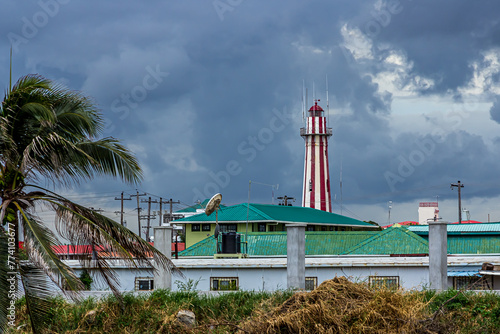 View of the old stone lighthouse tower in Georgetown, Guyana , South America against a background of a stormy sky with Cumulostratus clouds. Lighthouse - world tourism, attractions, landscape.