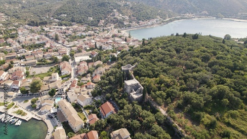 Foliage and cozy houses on Kassiopi shore, Corfu island, Greece photo