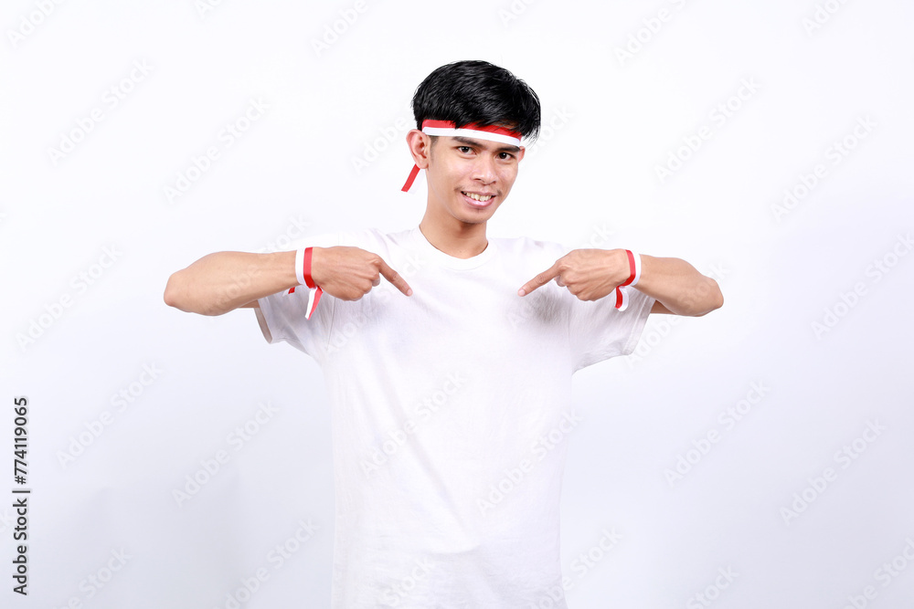 Naklejka premium Young asian boy with red white ribbon celebrating Indonesia independence day while pointing at himself
