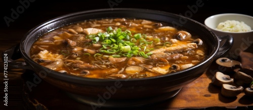 A delicious bowl of soup containing mushrooms and rice placed on a wooden table